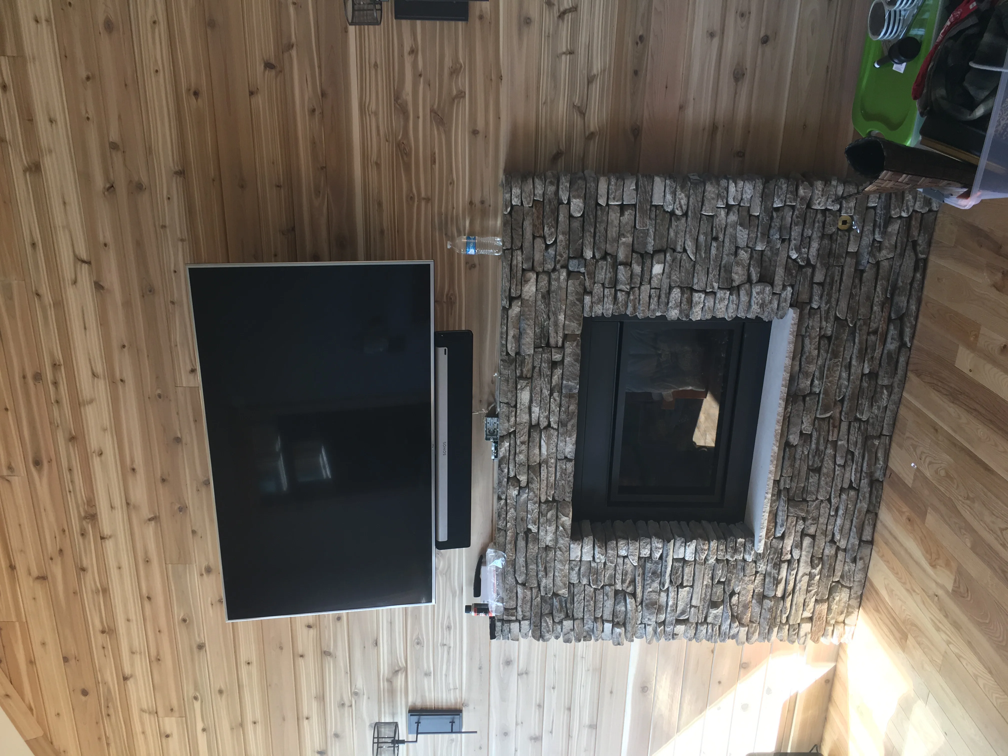 Wall-mounted television and soundbar above a stone fireplace