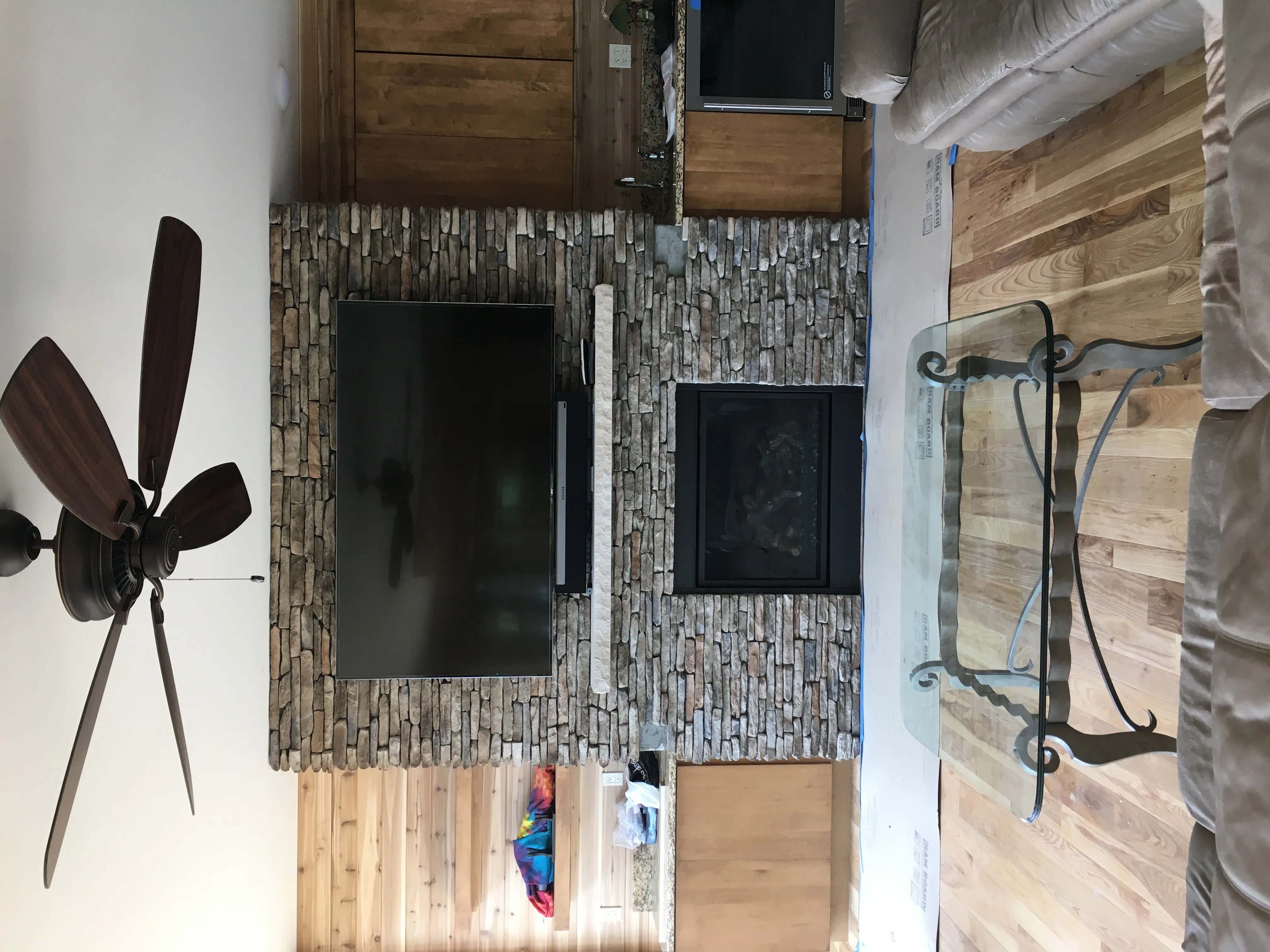 Integrated television and audio installation over a stone fireplace